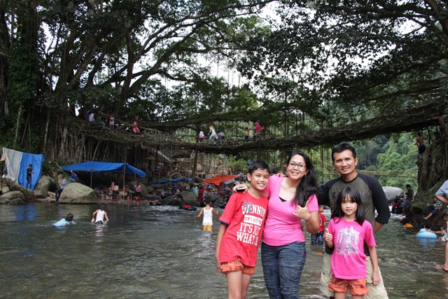 Foto keluarga dengan latar belakang Jembatan Akar yang unik