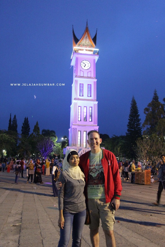 wisatawan berfoto dengan latar jam gadang