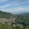 Panoramic view of Sawahlunto, a historic town in West Sumatra, Indonesia, surrounded by lush green hills and colonial-era buildings under a blue sky.